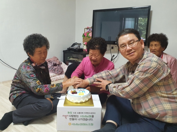 김 조합장이 75세 이상 어르신 조합원 생신을 축하하기 위해 케이크를 전달하고 있는 모습.